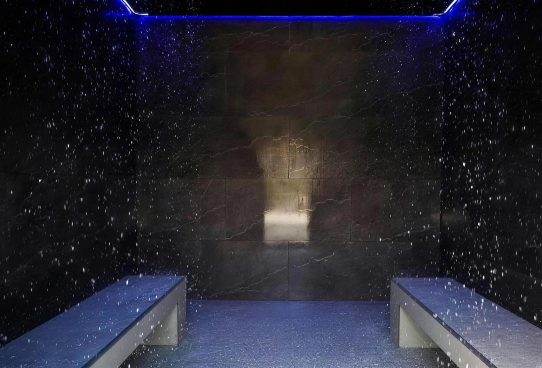 The Rain Room: dark stone, falling rain and blue light
